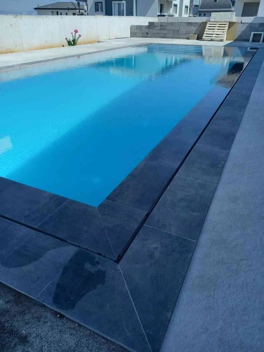 Safir mavisi suyu ve huzur veren atmosferiyle göz alıcı bir yüzme havuzu.